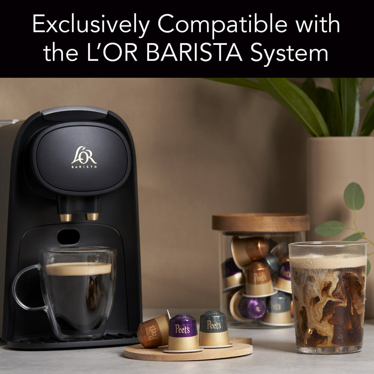 L'OR BARISTA coffee machine with coffee cups and capsules on a table.